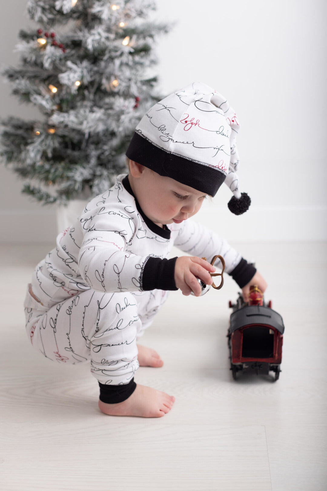 Child wearing Organic Holiday Kids' PJ & Cap Set in Writing Reindeer.