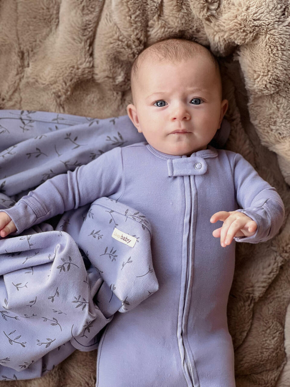 Child wearing Organic Zipper Footie in Amethyst. Credit: andrea.coonrod-