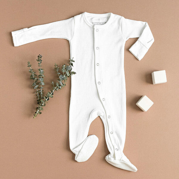 Organic Snap Footie in White on a tan background.