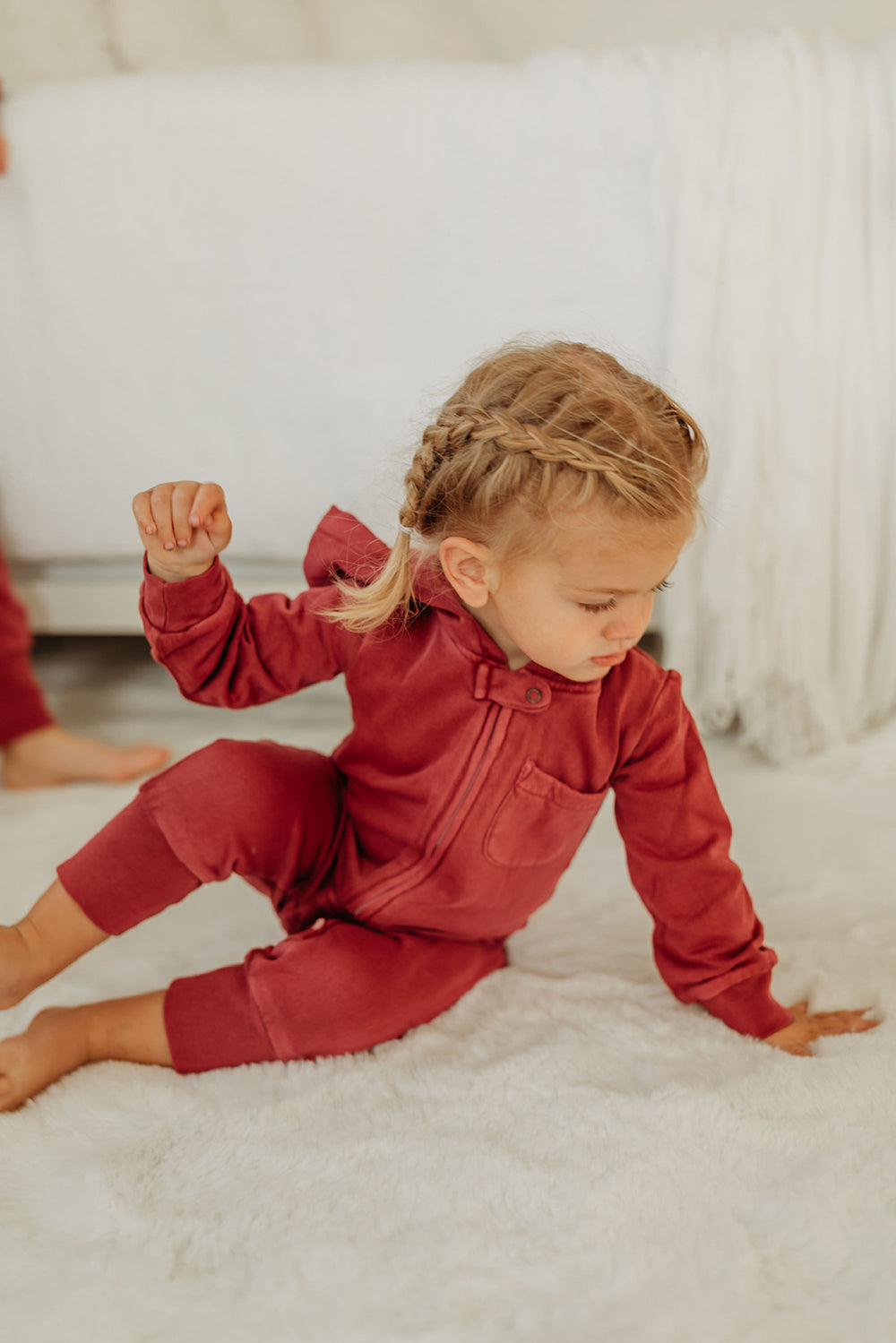 Child wearing Organic Cozy Zipper Romper in Cherry.