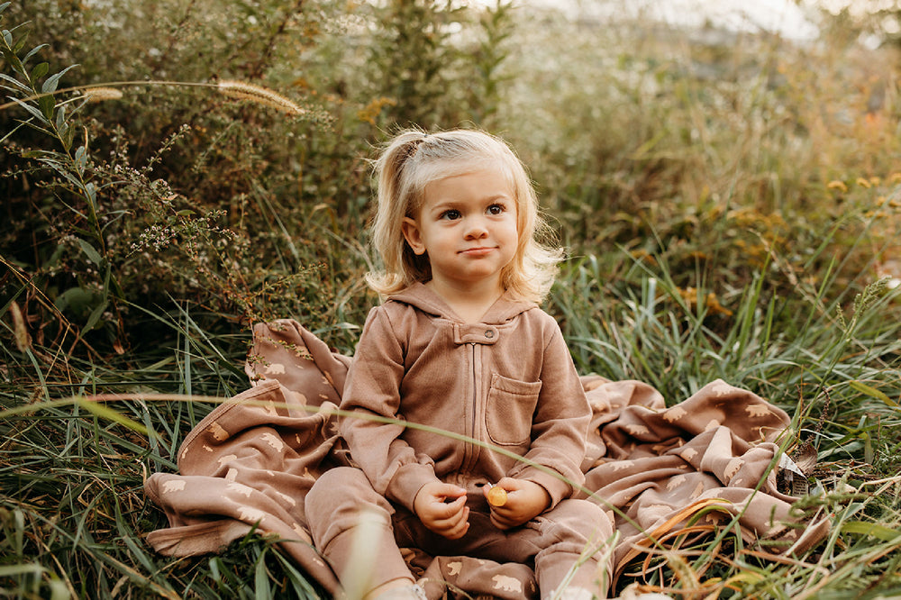 Child wearing Organic Cozy Zipper Romper in Latte.
