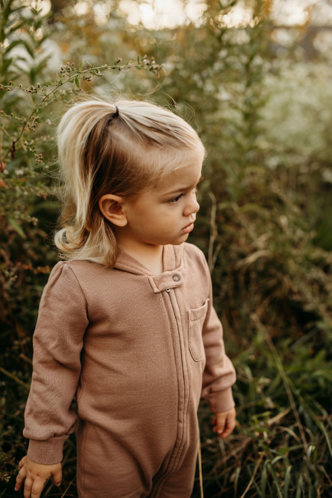 Child wearing Organic Cozy Zipper Romper in Latte.