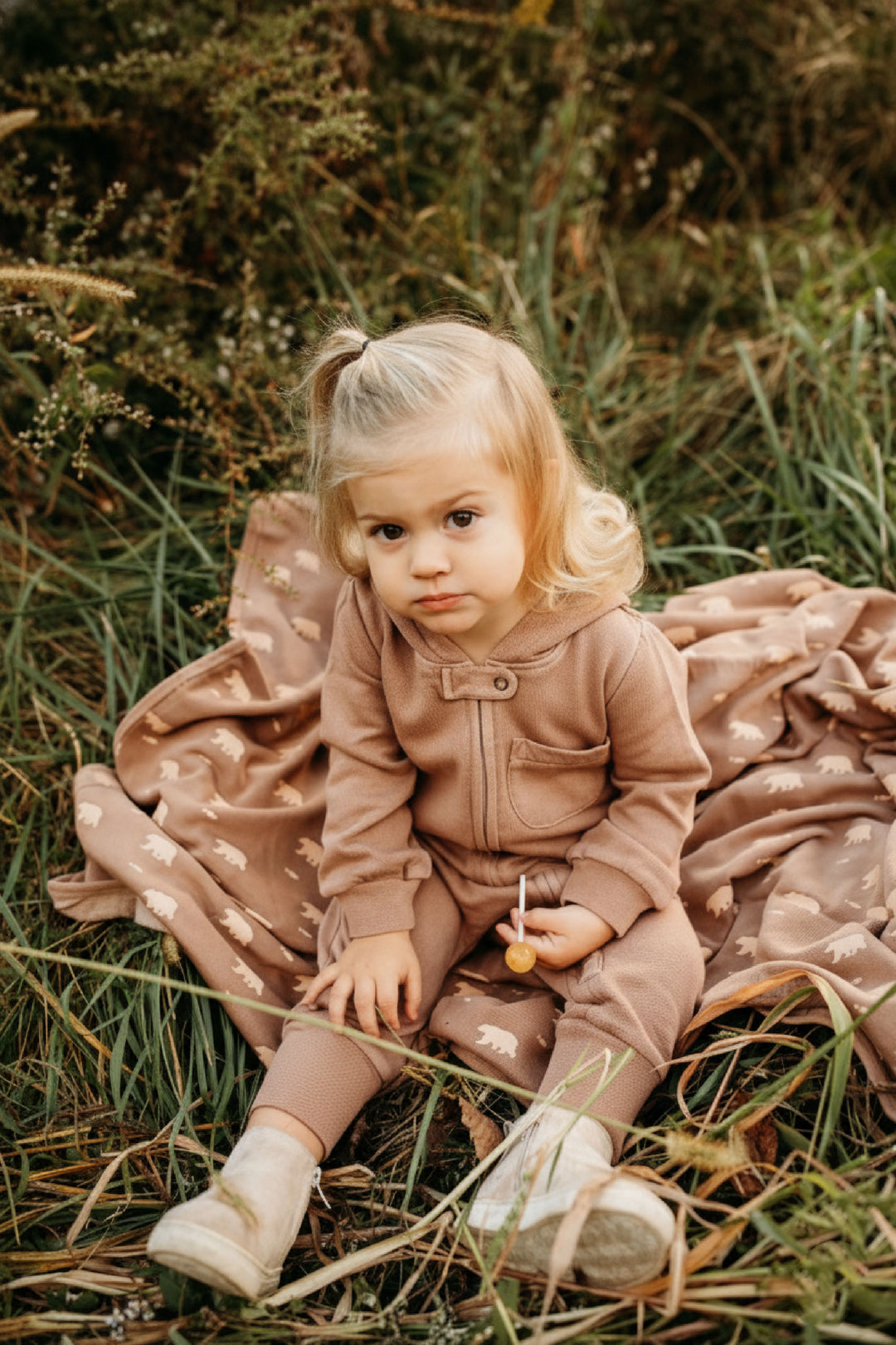 Child wearing Organic Cozy Zipper Romper in Latte.