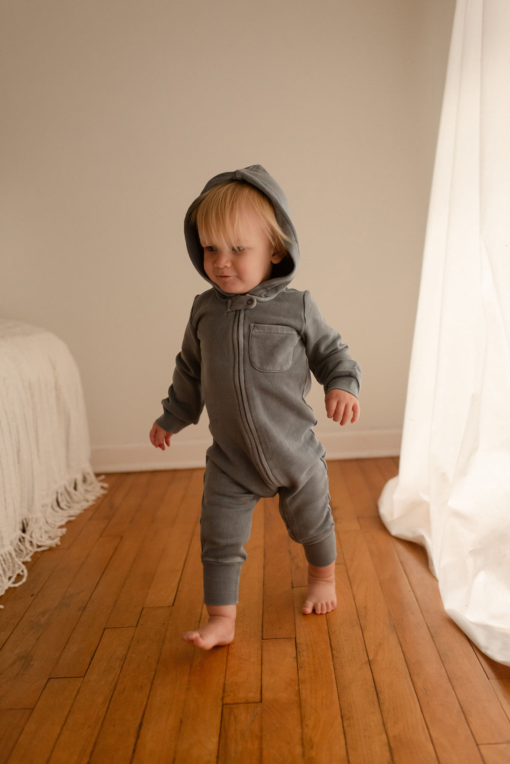 Child wearing Organic Cozy Zipper Romper in Moonstone.