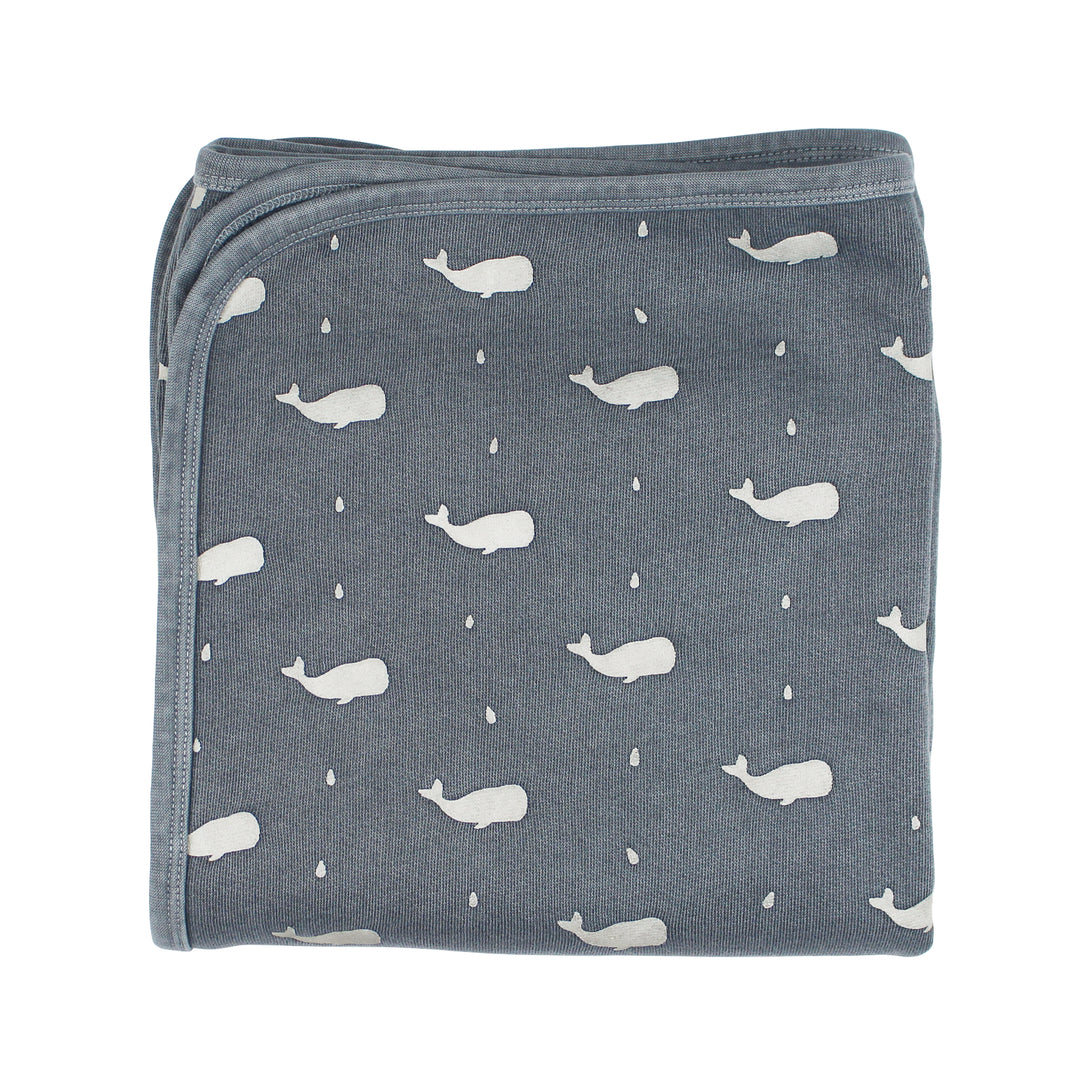 Folded blanket with whale pattern on a white background