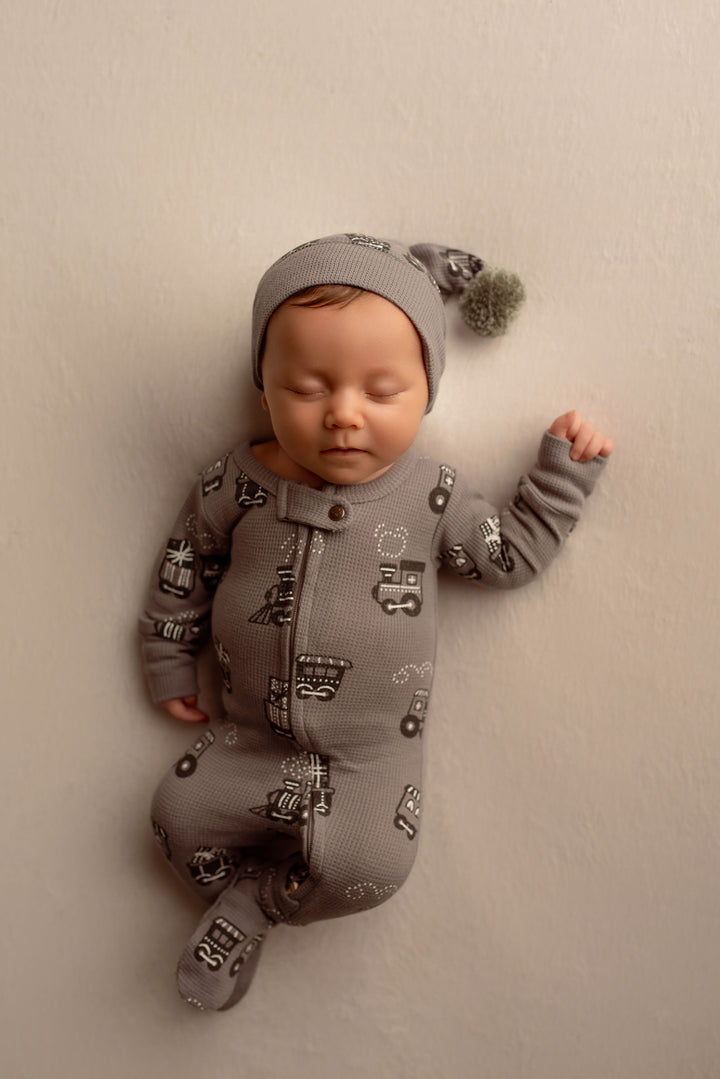 Child wearing Holiday Thermal 2-Way Zipper Footie & Cap Set in Tinsel Train.