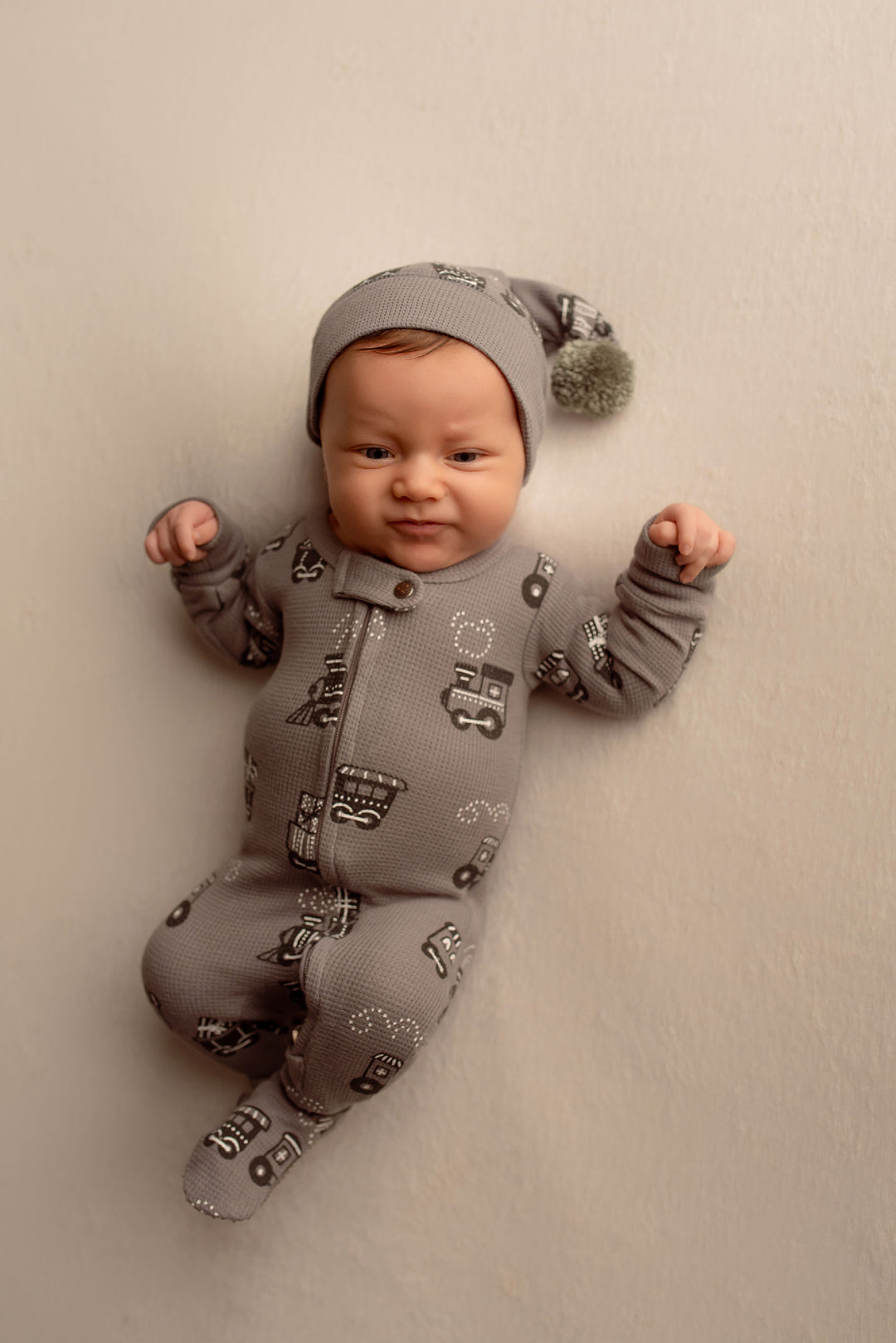 Child wearing Holiday Thermal 2-Way Zipper Footie & Cap Set in Tinsel Train.