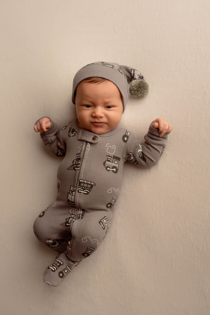Child wearing Holiday Thermal 2-Way Zipper Footie & Cap Set in Tinsel Train.