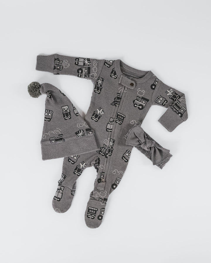 Child wearing Holiday Thermal 2-Way Zipper Footie & Cap Set in Tinsel Train.