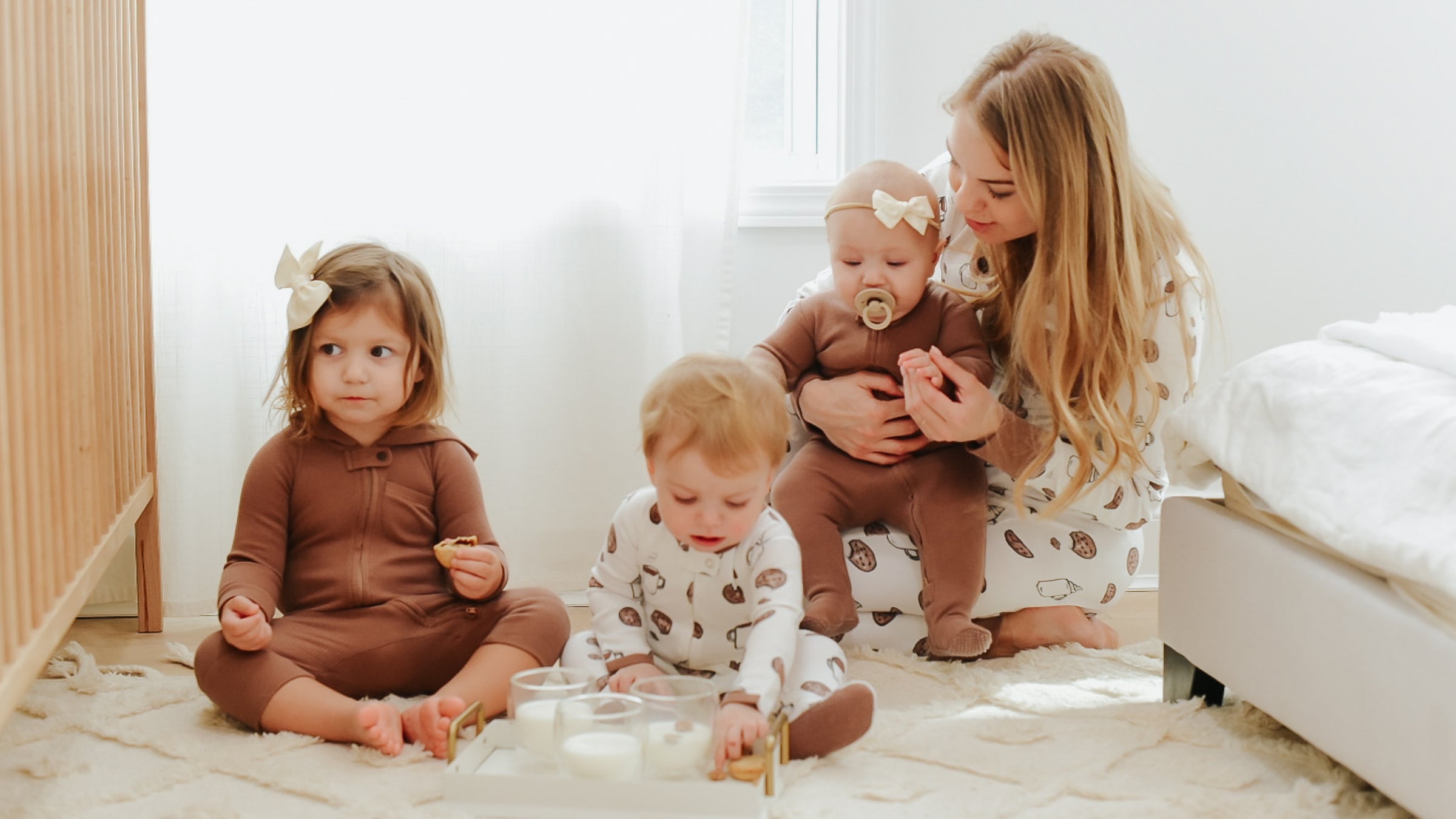 Woman with three children wearing outfits from the L'ovedbaby Holiday and Thermal collections.