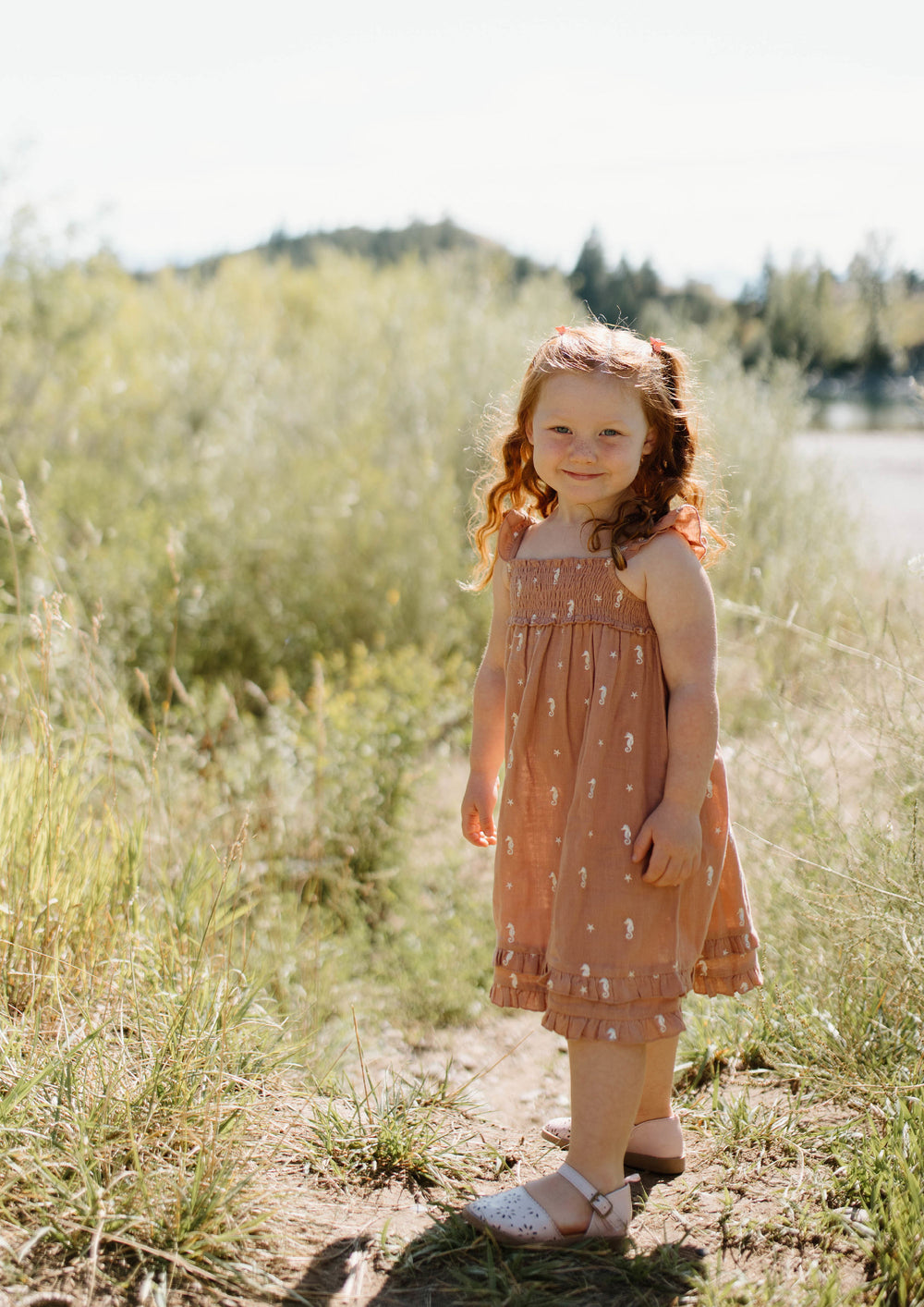 Child wearing Kids' Organic Muslin Summer Dress in Adobe Seahorse.