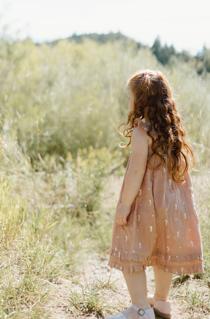 Child wearing Kids' Organic Muslin Summer Dress in Adobe Seahorse.