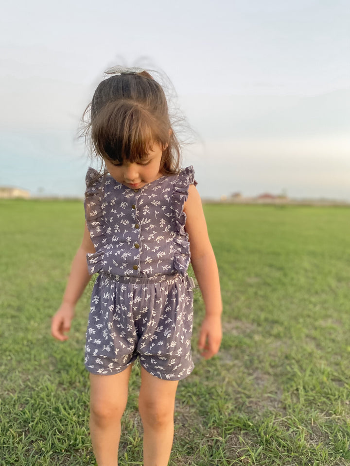 Child wearing a Kids' Organic Muslin Ruffle Jumper in Dusk Leaves