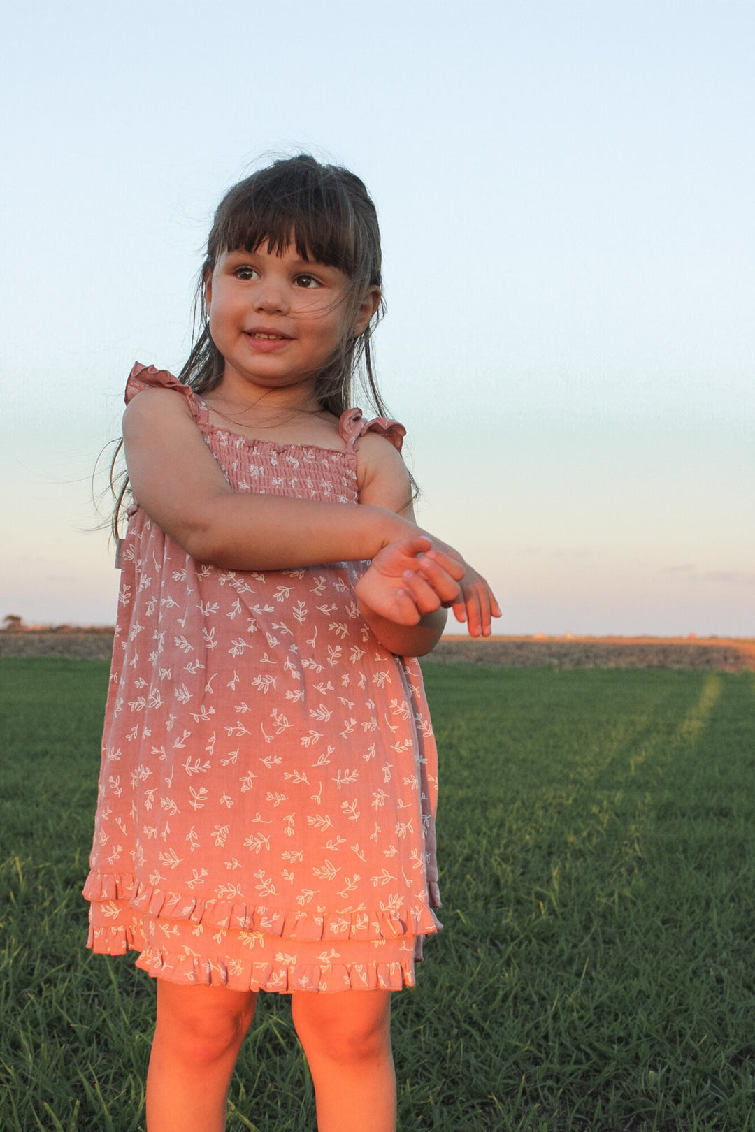 Child wearing Kids' Organic Muslin Summer Dress in Desert Rose Leaves.