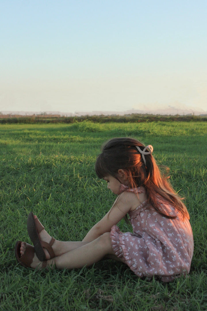 Child wearing Kids' Organic Muslin Summer Dress in Desert Rose Leaves.