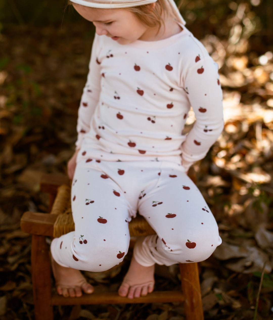 Child wearing Kids' Organic L/Sleeve PJ Set in Cherry Apple.