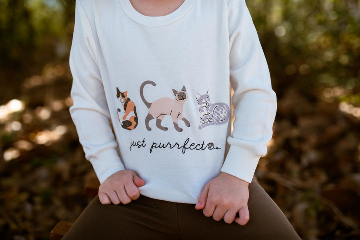 Child wearing Kids' Organic Crewneck Sweatshirt in 9 Lives.