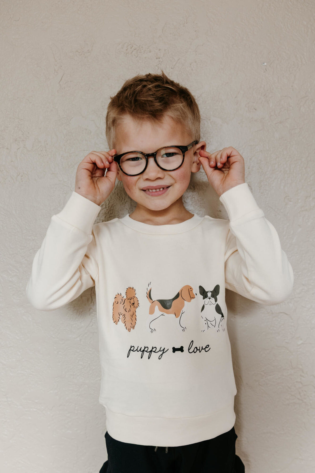 Child wearing Kids' Organic Crewneck Sweatshirt in Puppy Love.