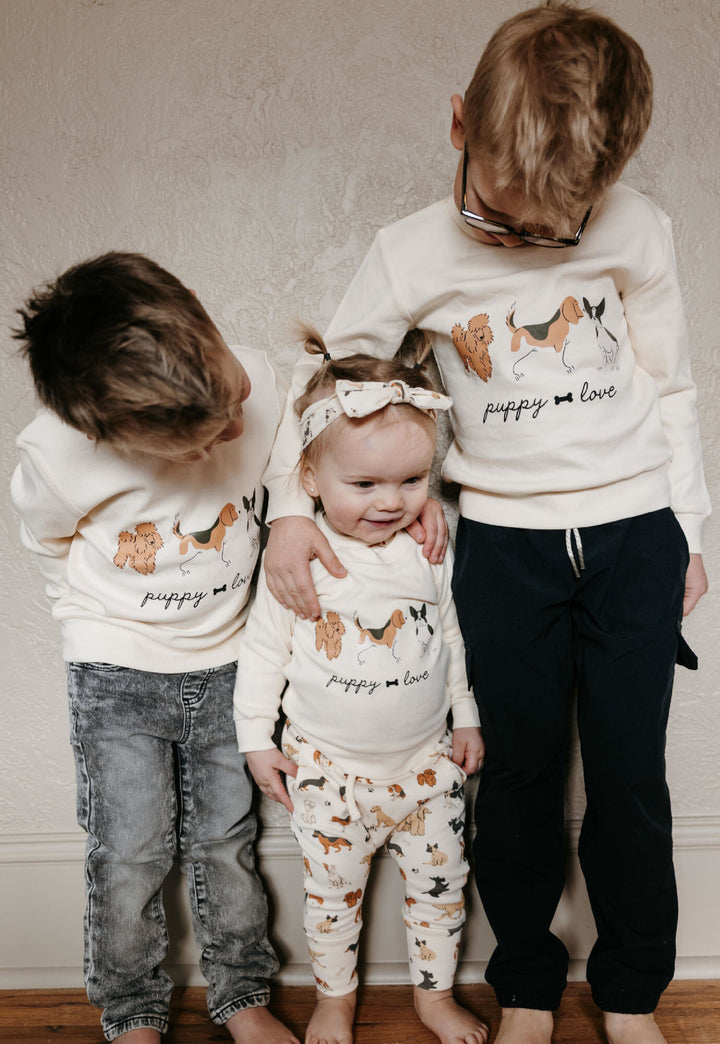 Child wearing Kids' Organic Crewneck Sweatshirt in Puppy Love.