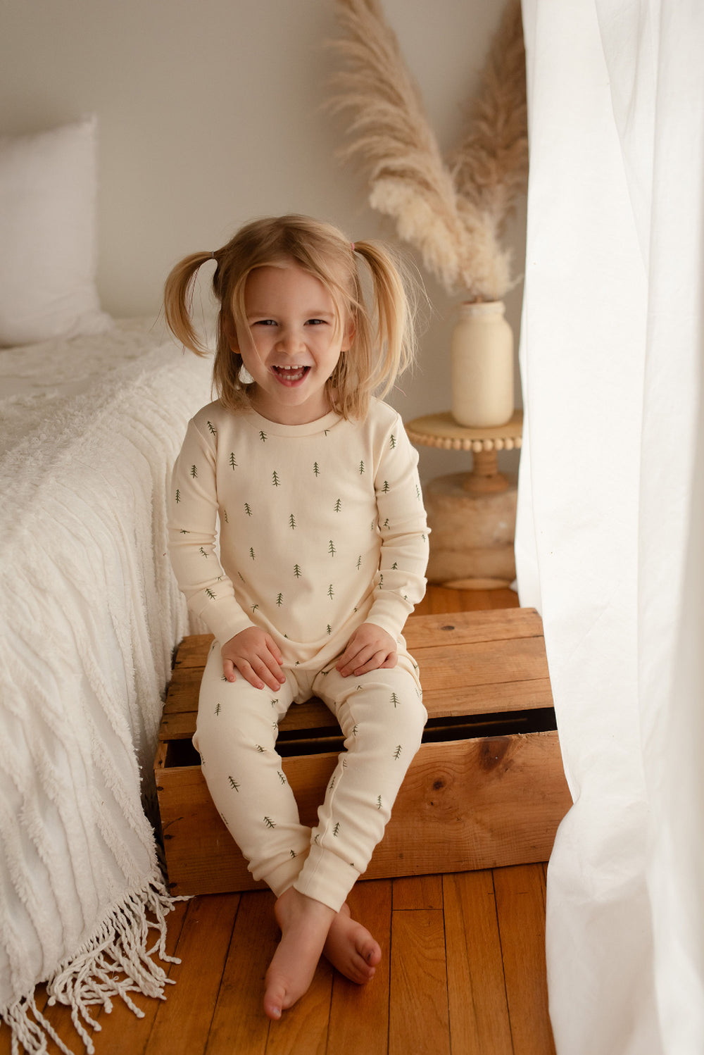 Child wearing Kids' Organic L/Sleeve PJ Set in Buttercream Tree.