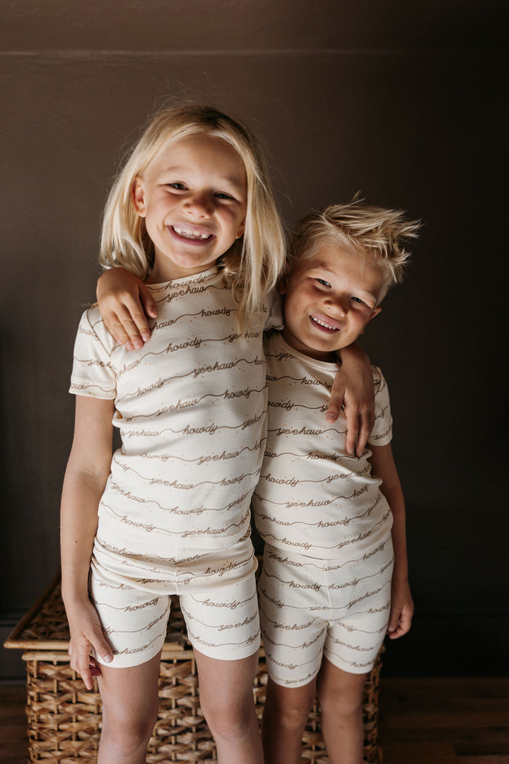 Child wearing Kids' Organic Short-Sleeve PJ Set in Howdy.