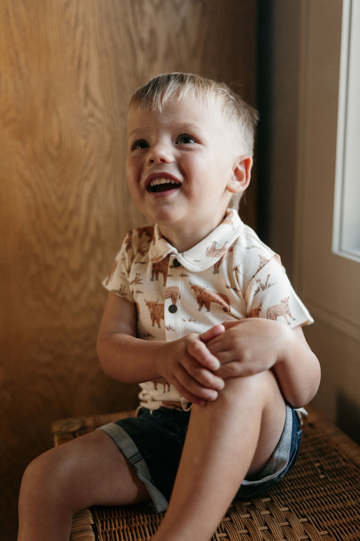 Child wearing Kids' Organic Button-Up S/Sleeve in Highland Cow.