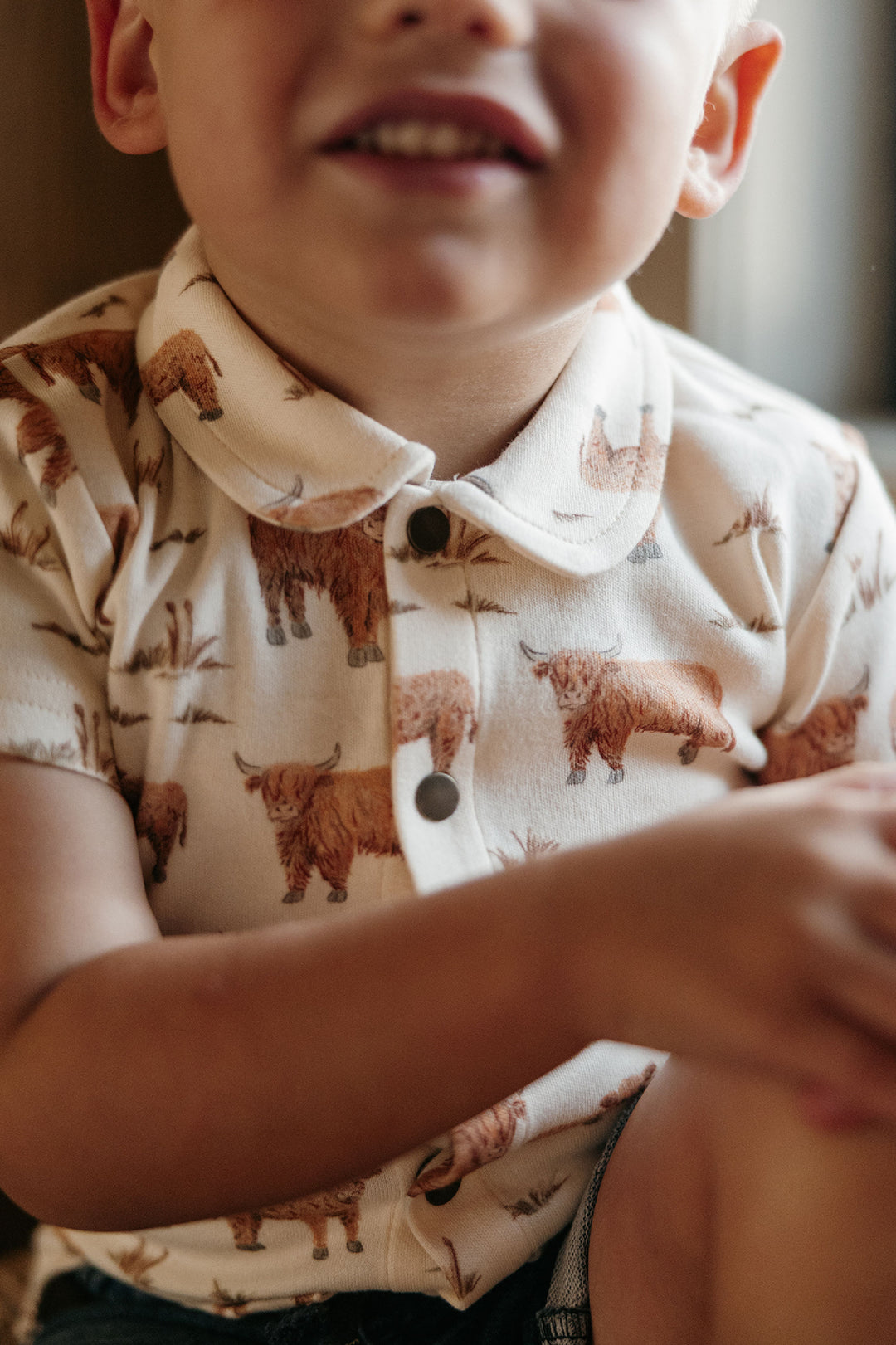 Child wearing Kids' Organic Button-Up S/Sleeve in Highland Cow.