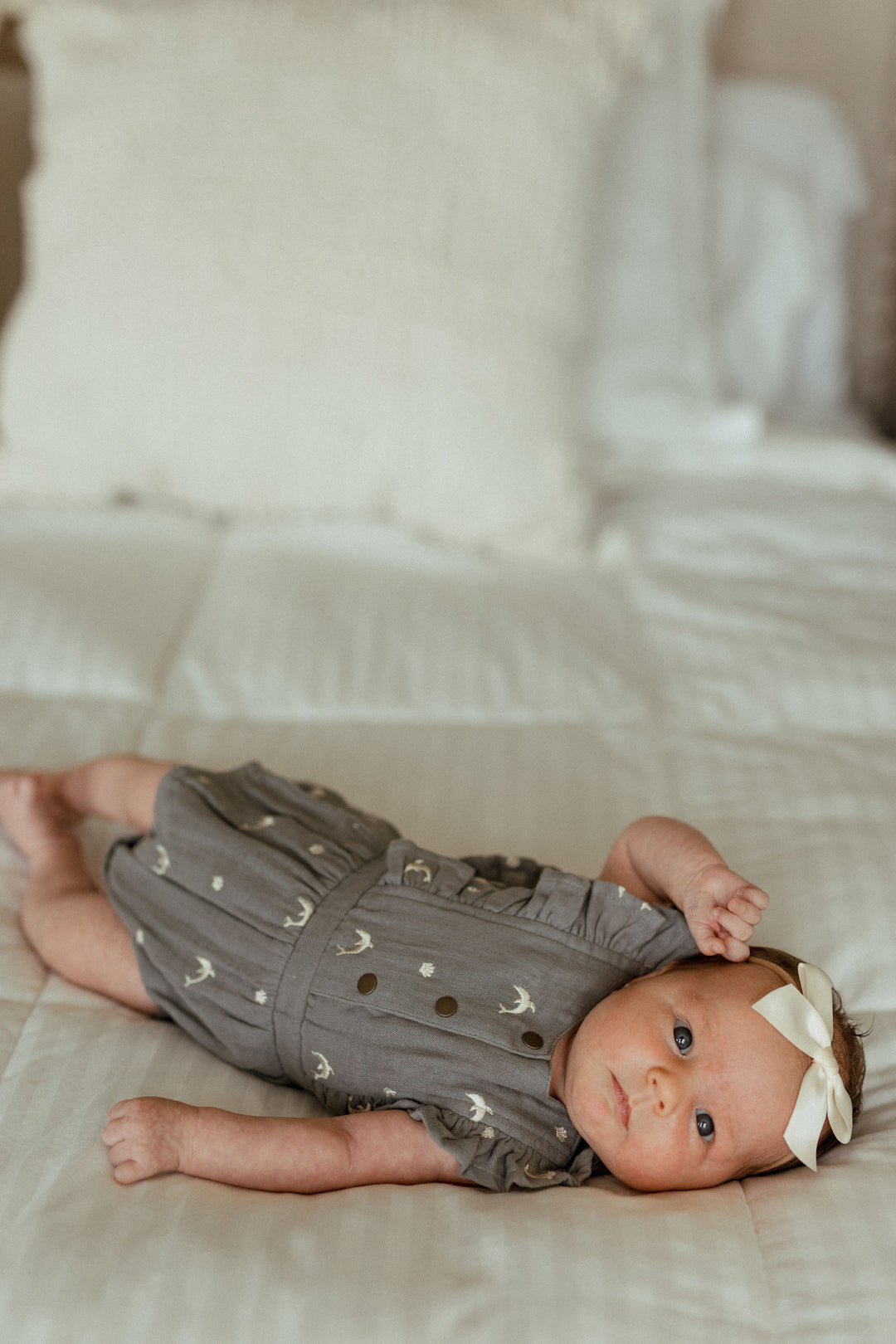 Child wearing Organic Muslin Ruffle Bodysuit in Moonstone Dolphin.