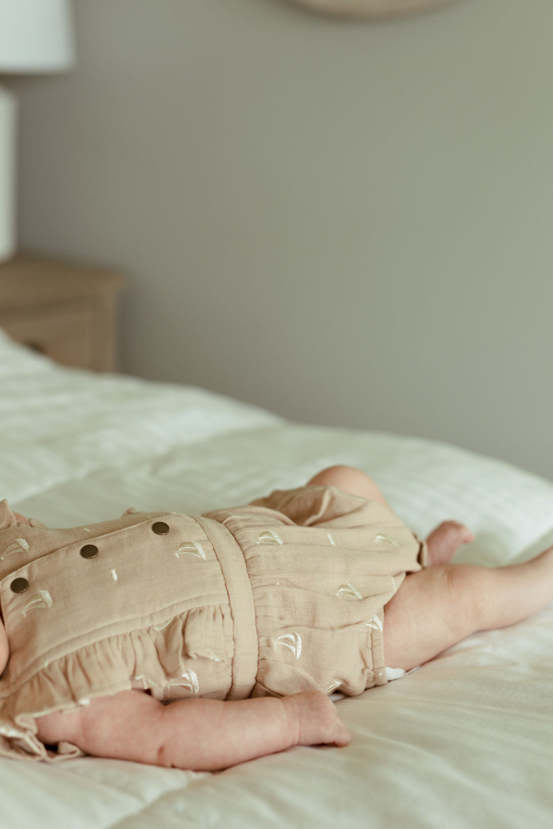 Child wearing Organic Muslin Ruffle Bodysuit in Oatmeal Sailboat.