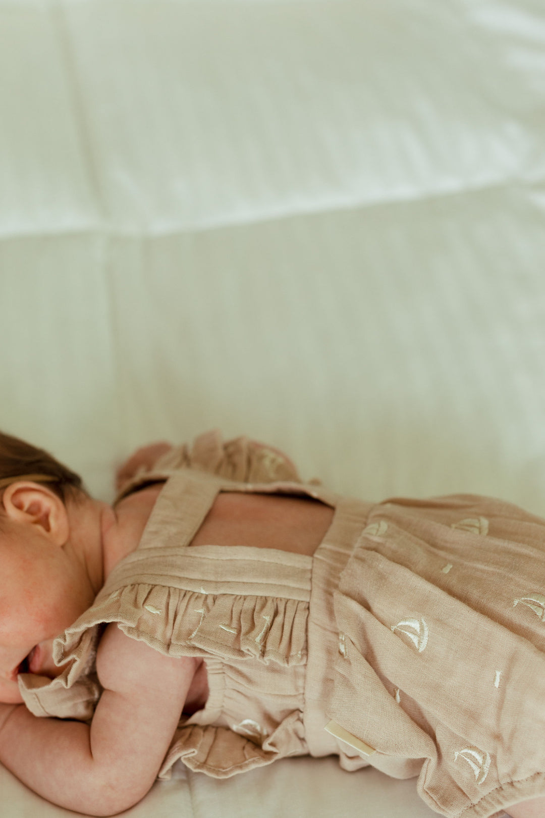 Child wearing Organic Muslin Ruffle Bodysuit in Oatmeal Sailboat.