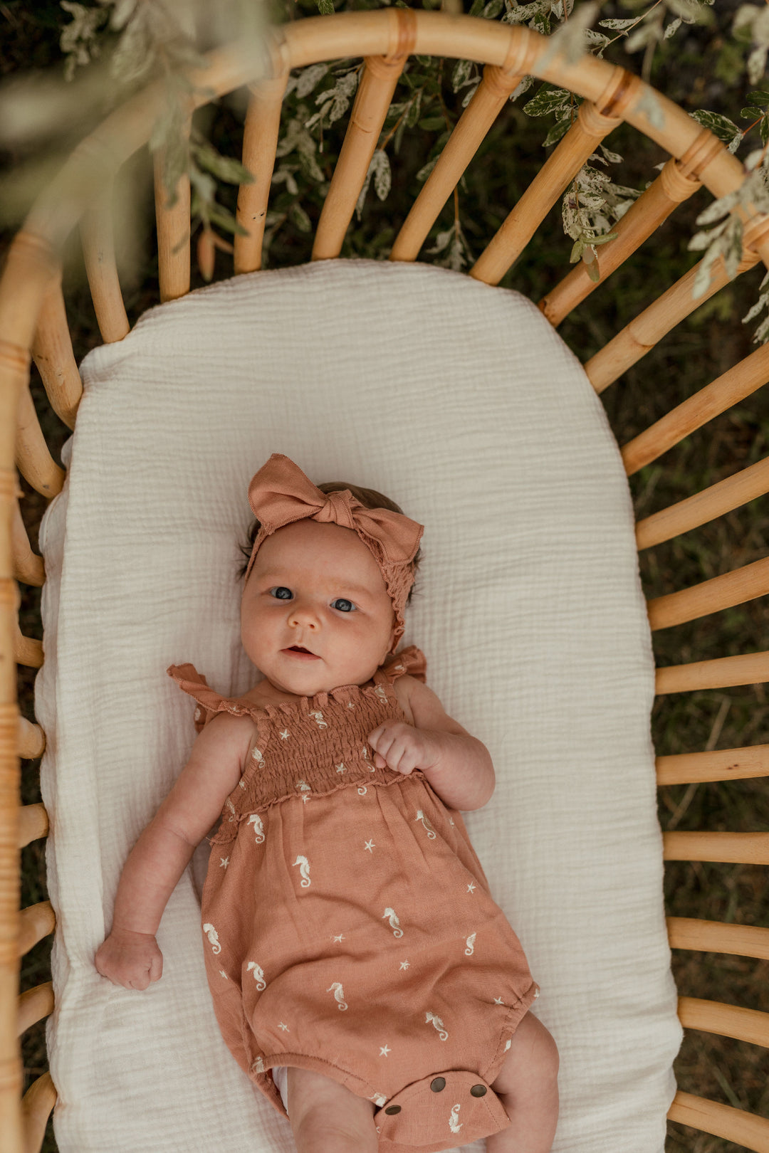 Child wearing Organic Muslin Sleeveless Bodysuit in Adobe Seahorse.