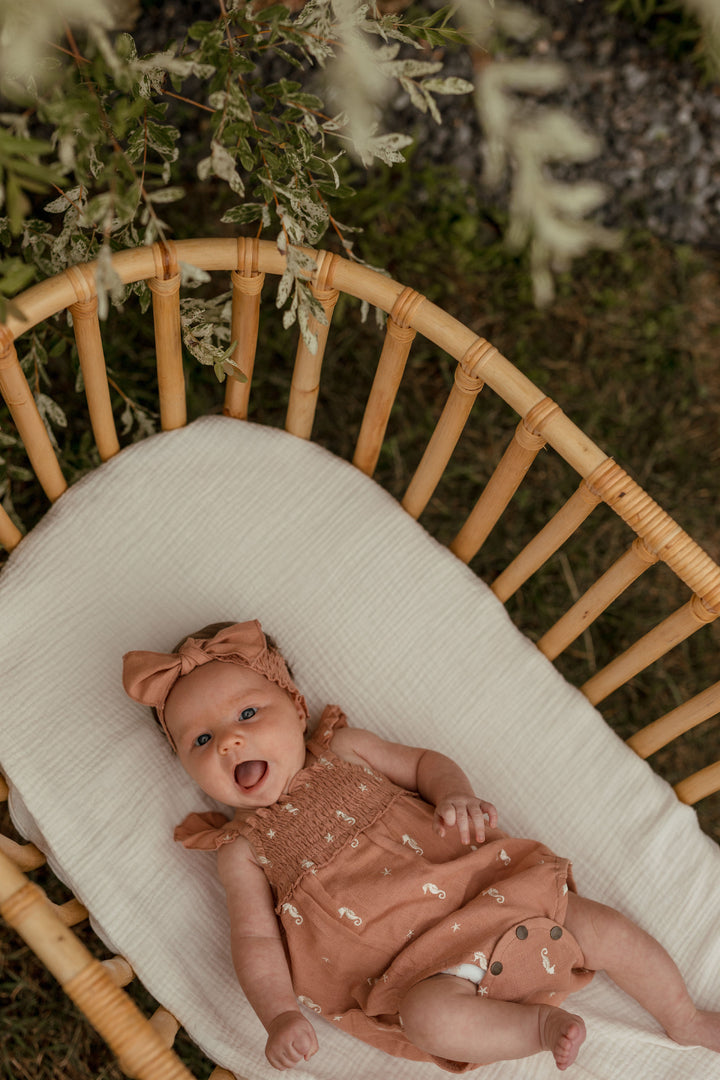 Child wearing Organic Muslin Sleeveless Bodysuit in Adobe Seahorse.