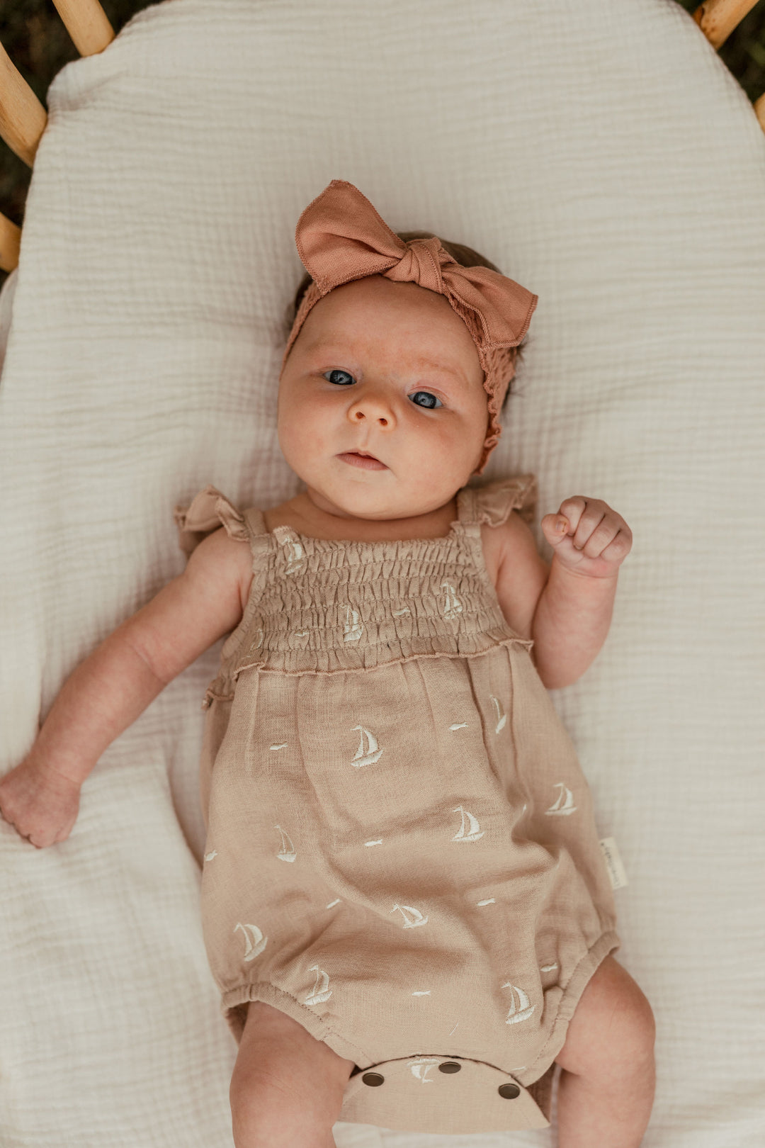 Child wearing Organic Muslin Sleeveless Bodysuit in Oatmeal Sailboat.