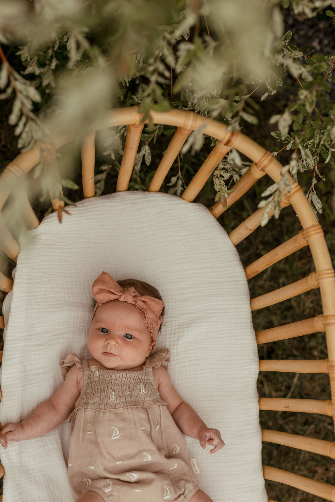 Child wearing Organic Muslin Sleeveless Bodysuit in Oatmeal Sailboat.