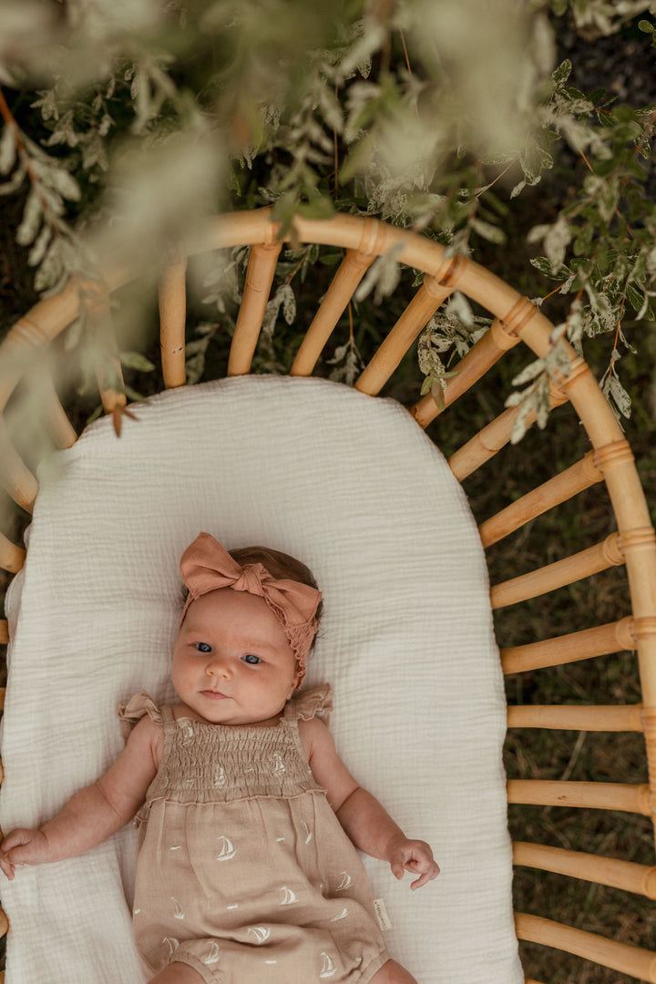 Child wearing Organic Muslin Sleeveless Bodysuit in Oatmeal Sailboat.