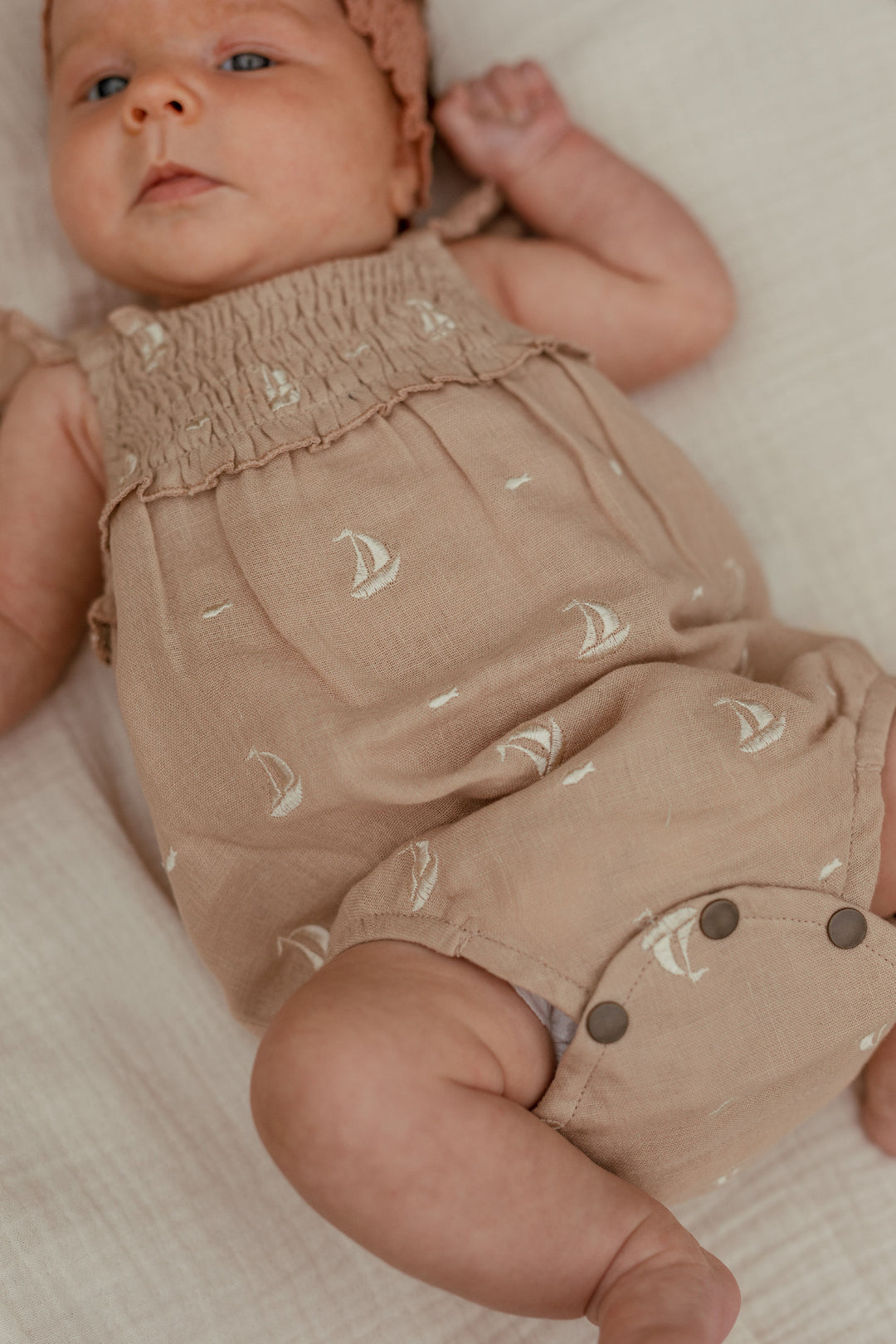 Child wearing Organic Muslin Sleeveless Bodysuit in Oatmeal Sailboat.