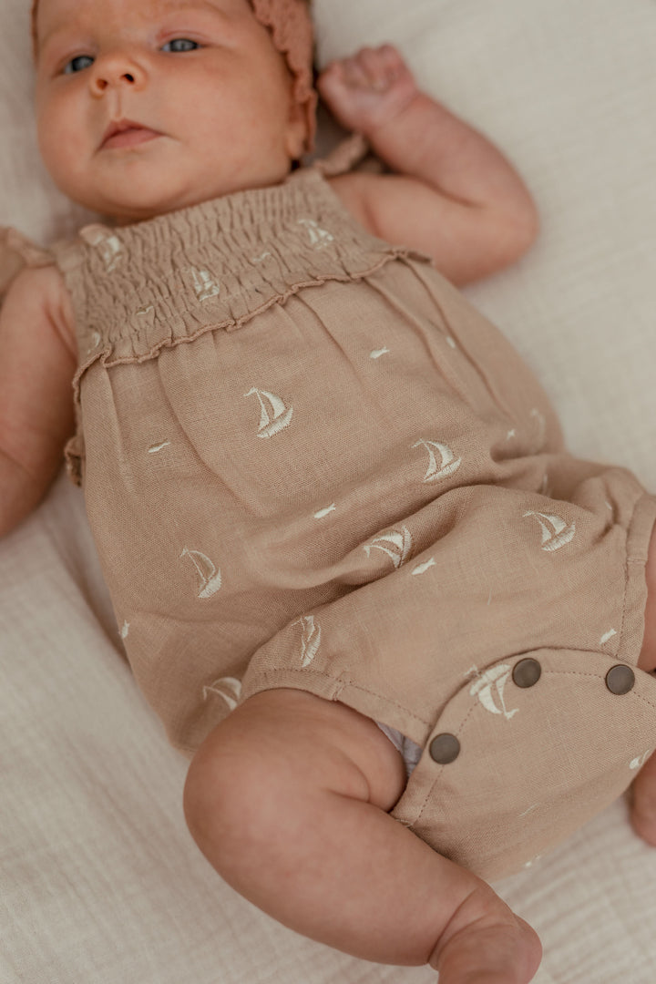 Child wearing Organic Muslin Sleeveless Bodysuit in Oatmeal Sailboat.
