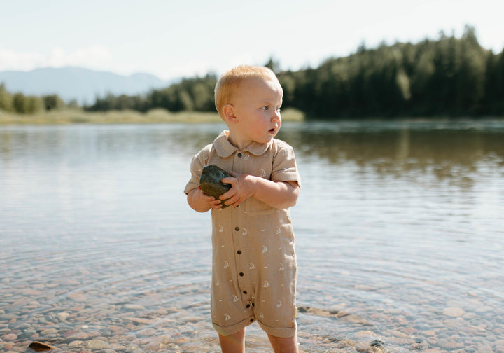 Child wearing Organic Muslin S/Sleeve Coverall in Oatmeal Sailboat.