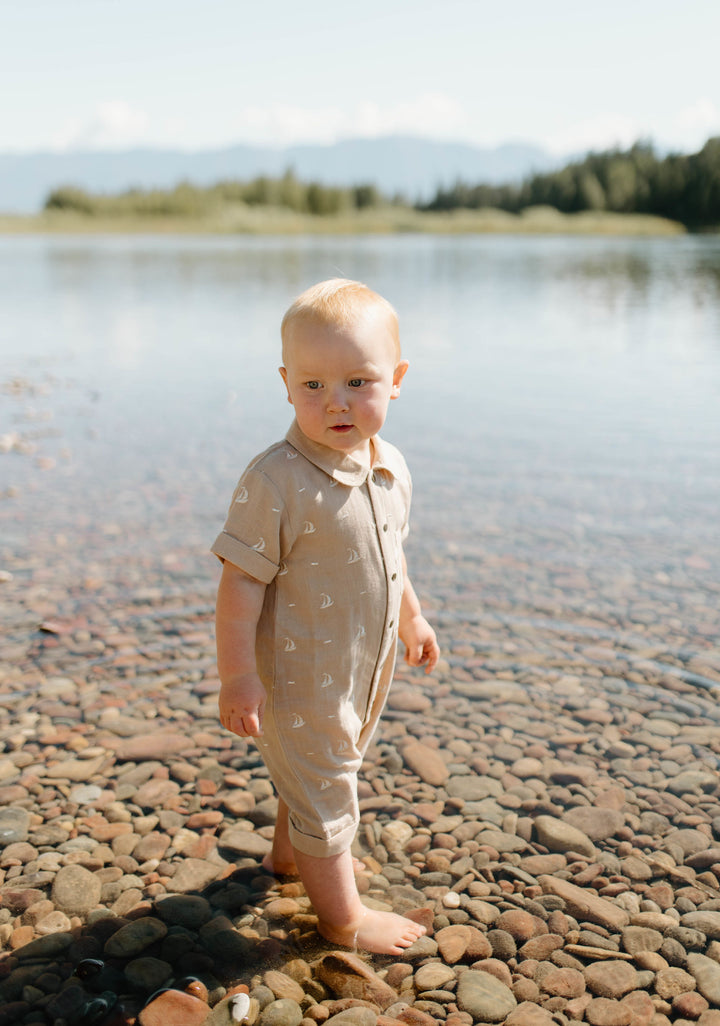 Child wearing Organic Muslin S/Sleeve Coverall in Oatmeal Sailboat.