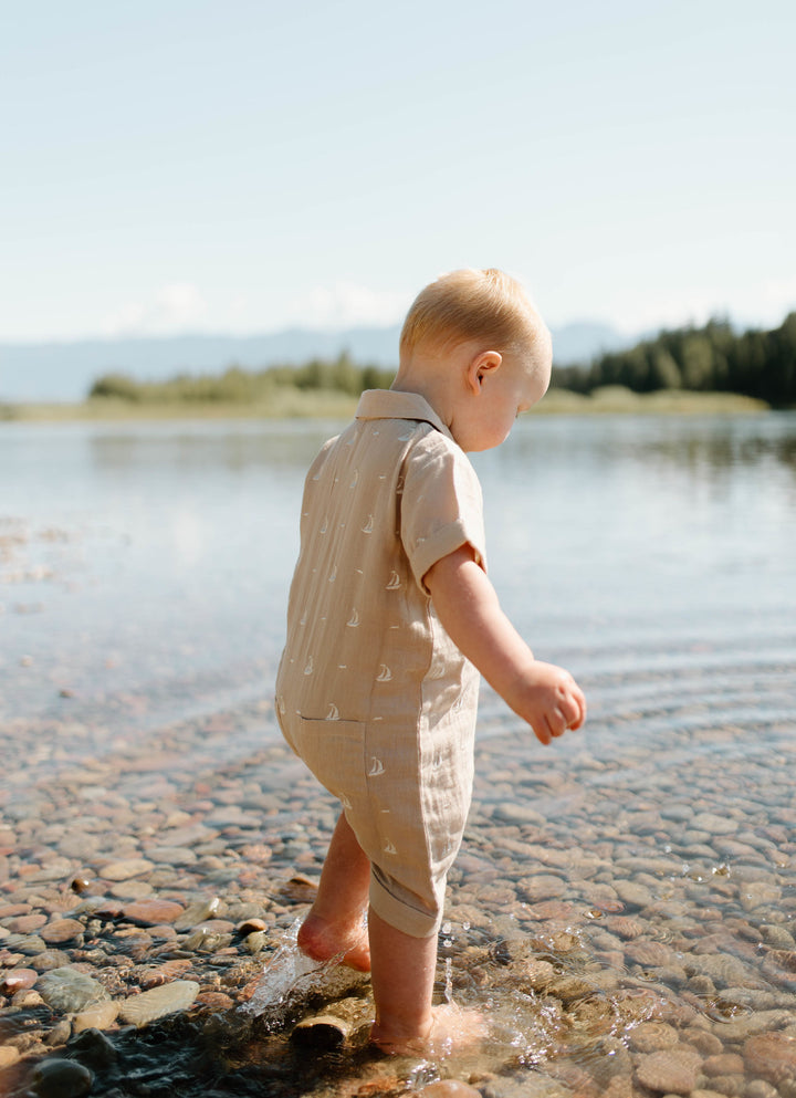 Child wearing Organic Muslin S/Sleeve Coverall in Oatmeal Sailboat.
