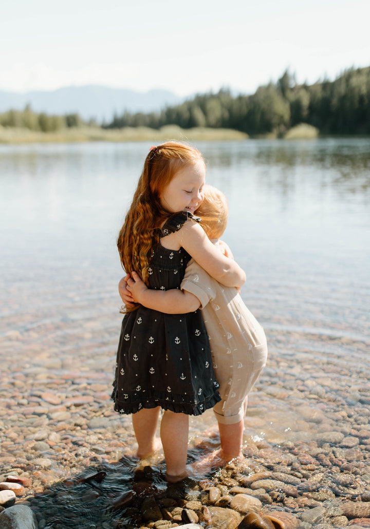 Child wearing Organic Muslin S/Sleeve Coverall in Oatmeal Sailboat.