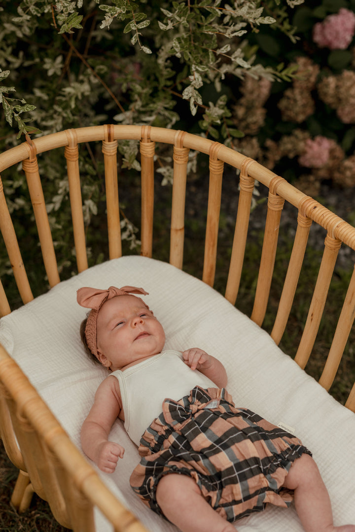 Child wearing Organic Muslin Ruffle Bloomer in Adobe Chia Plaid.