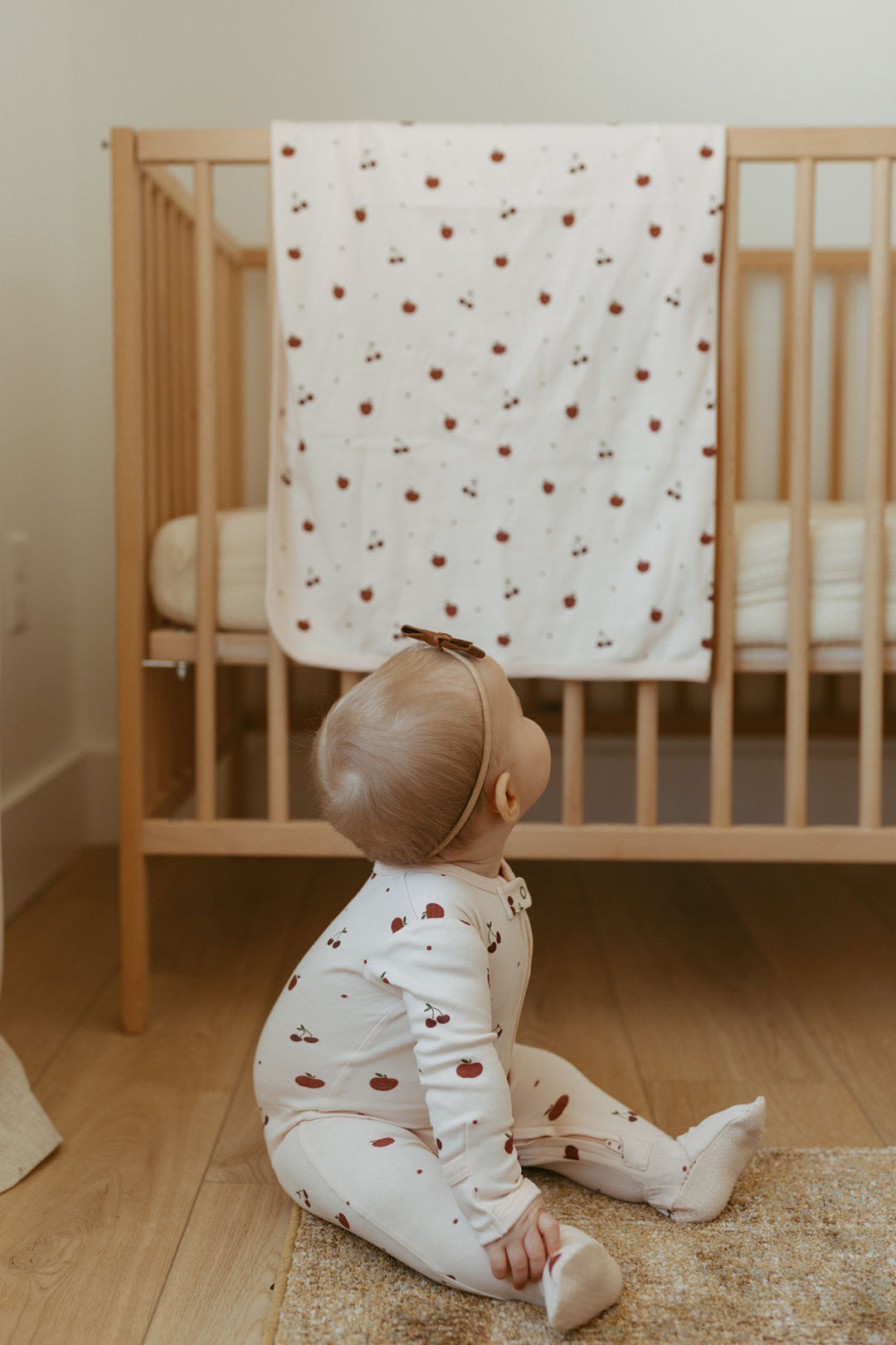 Child wearing Organic Blanket in Cherry Apple.