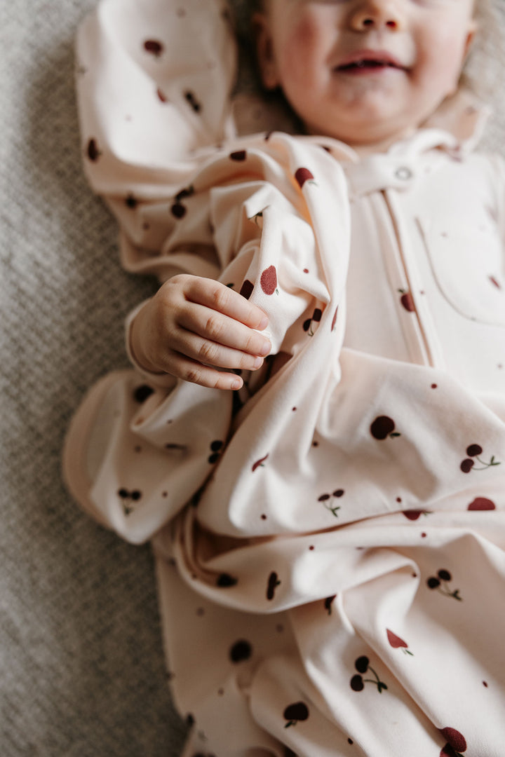 Child wearing Organic Blanket in Cherry Apple.