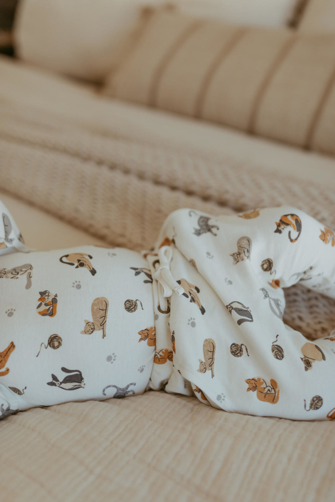 Child wearing Organic Long-Sleeve Bodysuit in 9 Lives.