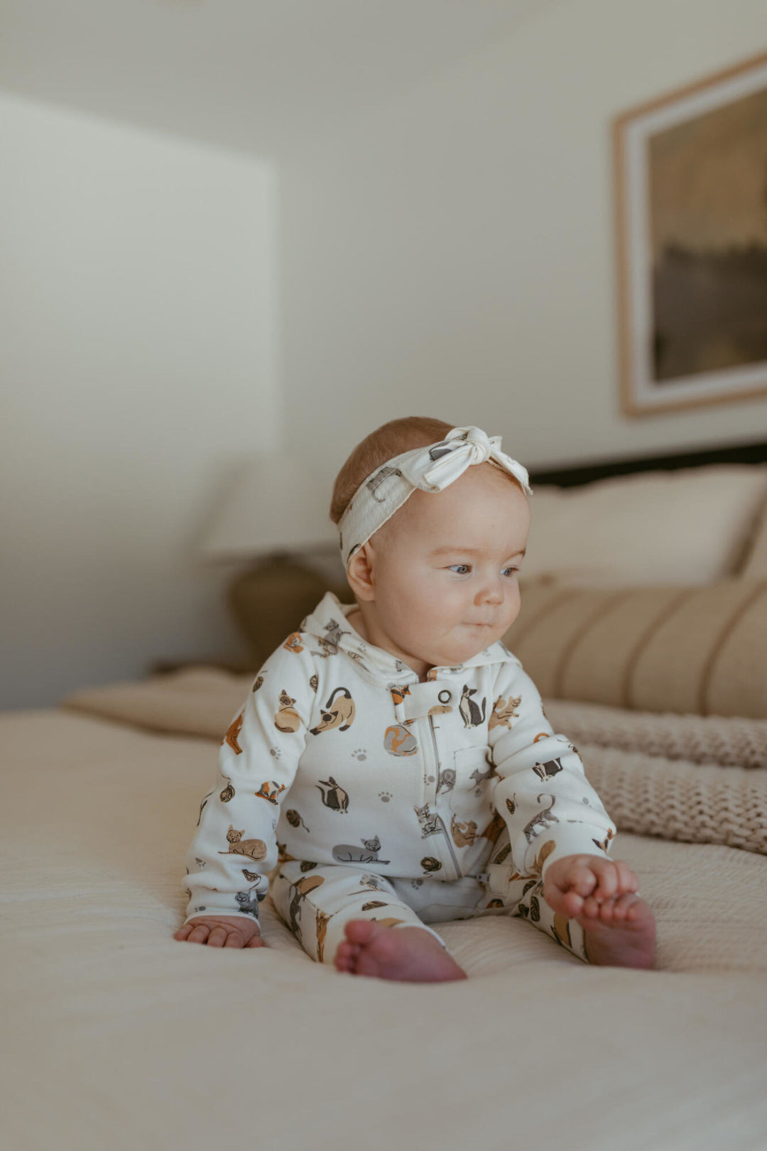 Child wearing Organic Hooded Zipper Romper in 9 Lives.