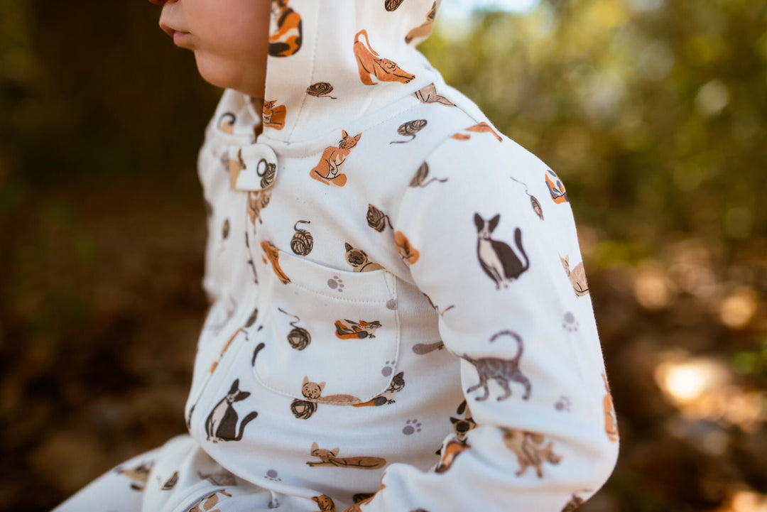 Child wearing Organic Hooded Zipper Romper in 9 Lives.