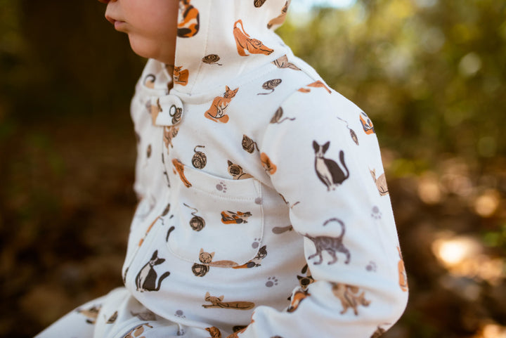 Child wearing Organic Hooded Zipper Romper in 9 Lives.