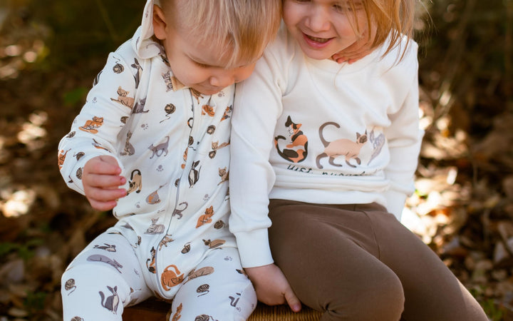 Child wearing Organic Hooded Zipper Romper in 9 Lives.