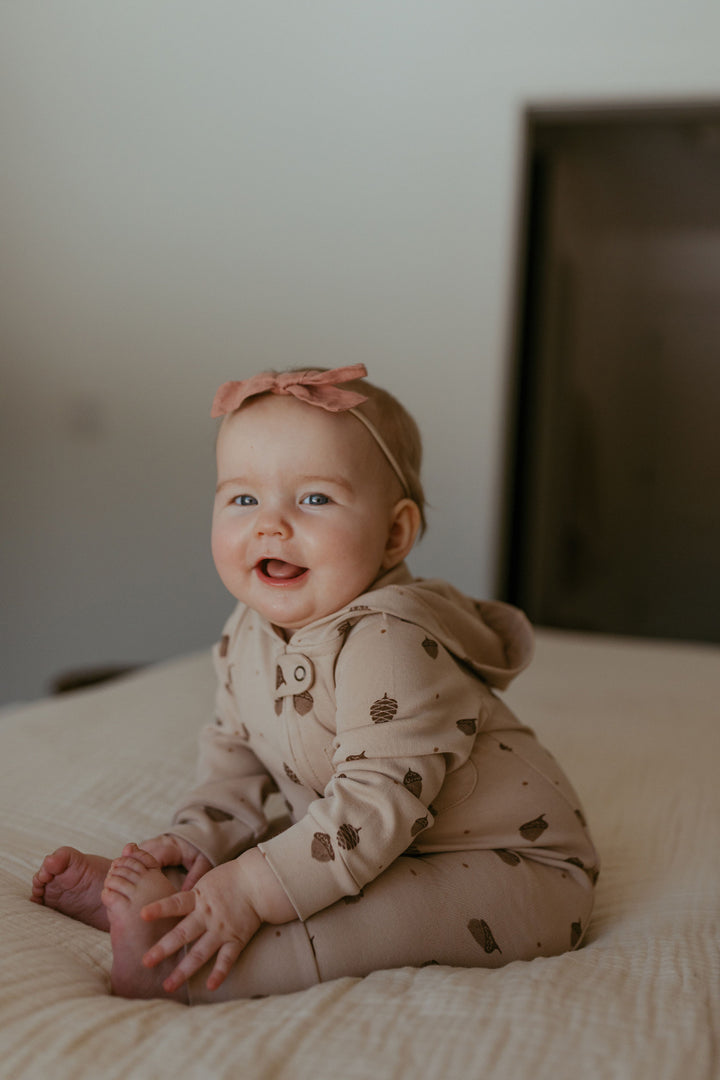 Child wearing Organic Hooded Zipper Romper in Little Acorn.